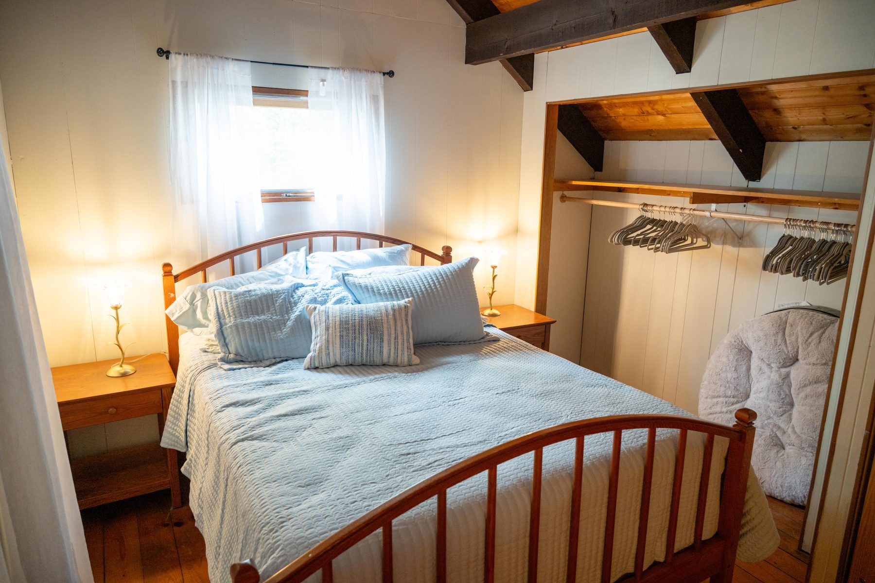Upstairs bedroom with a queen bed under a beamed cathedral ceiling